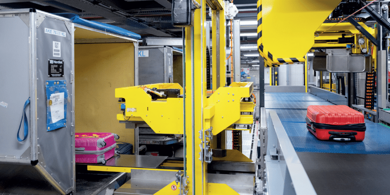 Red bag on a conveyer belt in the baggage handling section of an airport