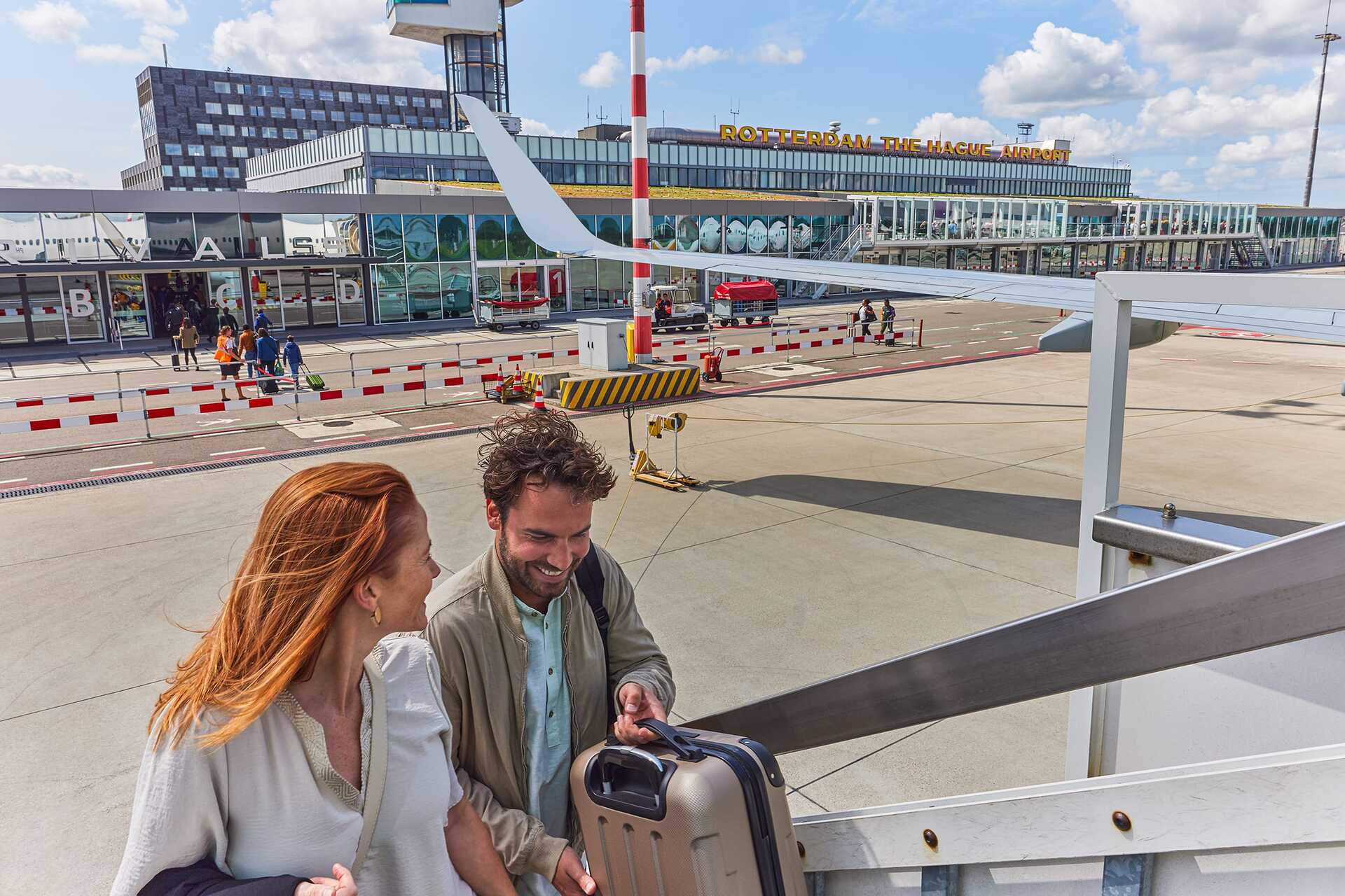 Couple boarding a plane at Rotterdam The Hague Airport